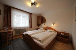 A bed or beds in a room at Hotel Garni Lärchenhof