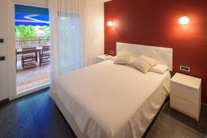 a bedroom with a large white bed and a balcony at SitgesBlues in Sitges