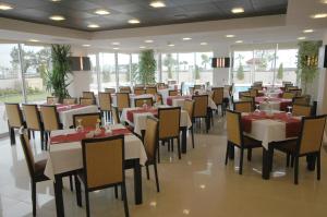 uma sala de jantar com mesas e cadeiras brancas em Blue Garden Hotel em Antalya