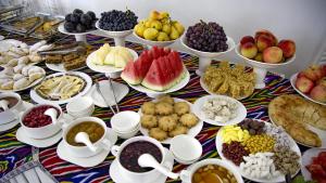 une table recouverte de beaucoup de différents types de nourriture dans l'établissement Hotel Caravan Serail, à Samarcande