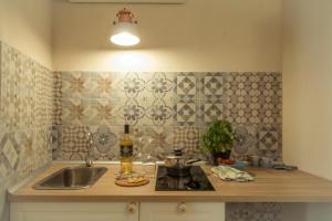 a kitchen with a sink and a counter with a bottle of wine at HolidayMonopoli in Monopoli