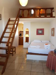 ein Schlafzimmer mit einem Bett und einer Treppe in der Unterkunft Abelonas Village in Megalochori