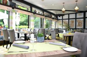 un restaurant avec une table et des chaises en bois dans l'établissement Moselromantik Hotel Weissmühle, à Cochem