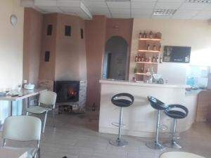 a bar with stools in a room with a fireplace at zajazd ''Marcówka" in Bakałarzewo