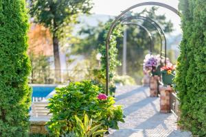 a garden with a bench and flowers and a pool at Villa Besha in Herceg-Novi