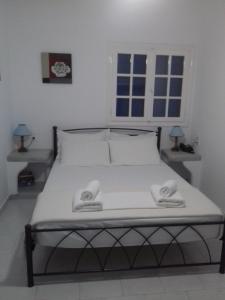 1 dormitorio con 1 cama con 2 toallas en Captain Stavros, en Pollonia