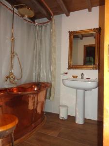 uma casa de banho com uma banheira e um lavatório em Pazo de Turbisquedo em Turbisquedo