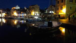 a boat is docked in a harbor at night at Villa Welcome in Vrboska