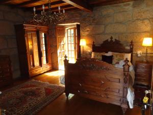 a bedroom with a large bed and a stone wall at Pazo de Turbisquedo in Turbisquedo