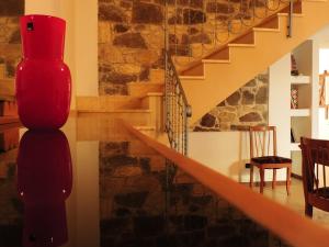 a living room with a staircase and a red vase at B&B Danonna in Ittiri