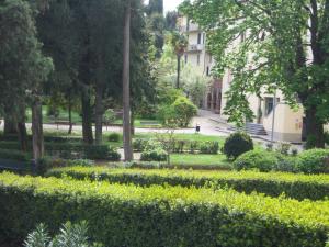 a garden with bushes and trees and a building at Casa Giulia on Francigena in Gambassi Terme