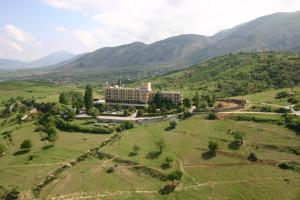 una vista aérea de un edificio en un campo con montañas en Hotel Kristal, en Korçë