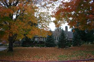 a house with autumn leaves in front of it at Rock Cottage Gardens B&B in Eureka Springs