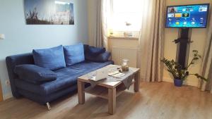 a living room with a blue couch and a coffee table at Haus OF in Binz