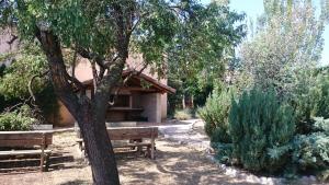 a park with two benches and a tree at Casa Rural El Gaiter in Aguaviva