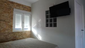 um quarto com uma cama e uma televisão na parede em Apartamento Sol del Mar em Villajoyosa