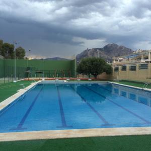 a large swimming pool with mountains in the background at La Xaquera in Busot