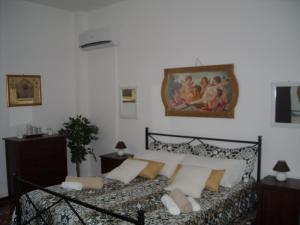 una camera da letto con un letto e un dipinto sul muro di Giovannixxlll B&B a Catania