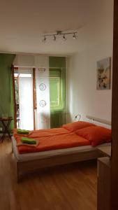 a bedroom with a large bed with an orange blanket at Zur Traube in Kestert