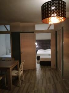 ビシェーリエにあるUna Riga sul Mareのベッドルーム1室(ベッド1台、テーブル、シャンデリア付)