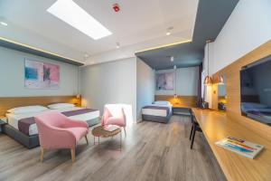 a hotel room with two beds and a flat screen tv at Madrugada Old City in Stari Grad