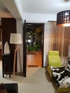 a living room with a green chair and a door at Villa Galleria in Perivolia