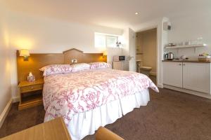 a bedroom with a large bed and a kitchen at Annexe at Gosfield Lake in Gosfield