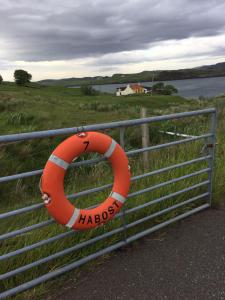 an orange life preserver is attached to a fence at 7 Habost in Balallan
