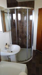 a bathroom with a glass shower and a sink at 7 Habost in Balallan