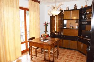 a dining room with a wooden table and a kitchen at Pratoranieri - Sparviero in Follonica