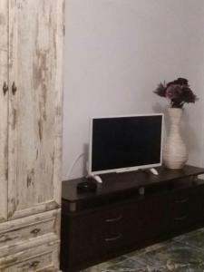 a television on a dresser with a vase on it at Akrotiriya Sea View in Nesebar