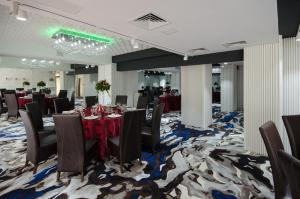 ein Konferenzraum mit Tischen, Stühlen und Teppichboden in der Unterkunft Hotel Andre´s in Craiova