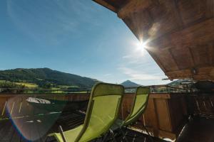 a pair of chairs on a balcony with a view of the mountains at Haus Bergkraft in Leogang