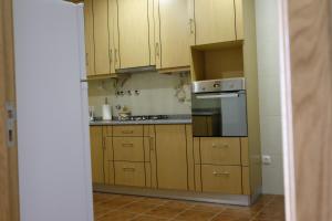 a kitchen with wooden cabinets and a stove top oven at Casa Lagar in Vale de Cambra