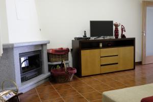 a living room with a tv and a fireplace at Casa Lagar in Vale de Cambra