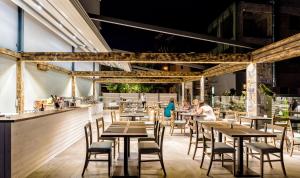 a restaurant with wooden tables and chairs and a bar at Pollis Hotel in Hersonissos
