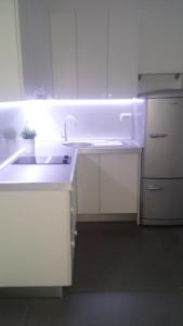 a white kitchen with a sink and a refrigerator at Apartment Doma in Međugorje