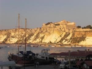 a boat docked in a harbor with a castle on a hill at Hotel Eden in San Domino
