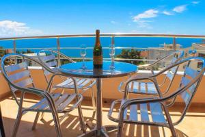 a table with two chairs and a bottle of wine on a balcony at Casa Hena in Ulcinj