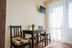 a dining room with a table and chairs and a tv at Milan Apartmanok in Siófok