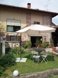 a table and chairs with an umbrella in a yard at B&B Coco Loco in Sesto Calende