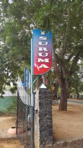 a sign for a restaurant next to a fence at Isuruma Rest in Kataragama