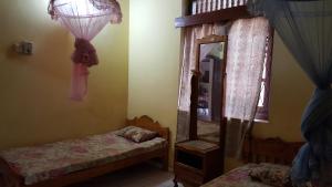a small bedroom with two beds and a mirror at Isuruma Rest in Kataragama
