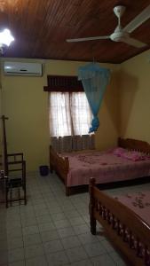 a bedroom with two beds and a ceiling fan at Isuruma Rest in Kataragama