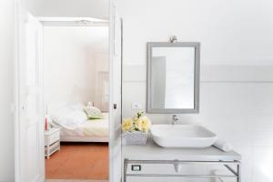 RoppoloにあるRose Suite Apartmentsのバスルーム(シンク、鏡、ベッド付)