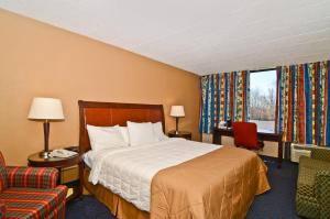 a hotel room with a bed and a chair at Pocono Resort & Conference Center - Pocono Mountains in Lake Harmony
