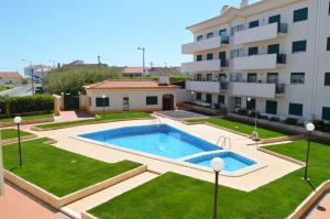 a swimming pool in a yard next to a building at Apartment Peniche swimming pool in Peniche de Cima