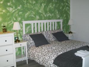 1 dormitorio con cama blanca y pared verde en B&B La Bottega en Pergine Valsugana