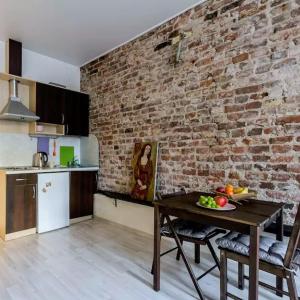 a kitchen with a table and a brick wall at Apart Hotel Arka in Saint Petersburg
