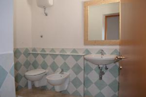 リオーラ・サルドにあるAgriturismo Il Melogranoのバスルーム(洗面台2台、トイレ、鏡付)